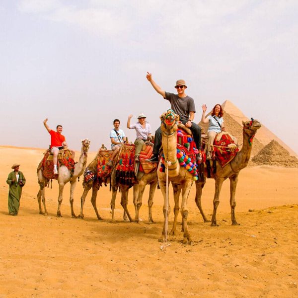 Fotos De Unos Turistas Cabalgando Camellos En La Zona De Las Piramides